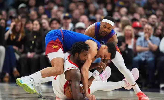 Houston Rockets forward Tari Eason, front bottom, fights for control of a loose ball with Denver Nuggets forward Spencer Jones, front top, and guard Bruce Brown in the first half of an NBA basketball game, Wednesday, March 11, 2026, in Denver. (AP Photo/David Zalubowski)
