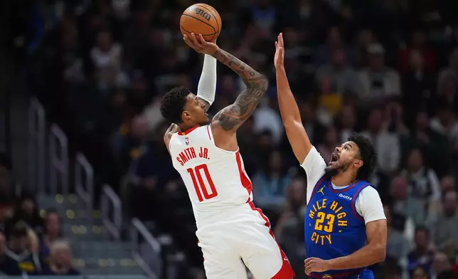 Houston Rockets forward Jabari Smith Jr., left, shoots for a basket over Denver Nuggets forward Cameron Johnson in the first half of an NBA basketball game Wednesday, March 11, 2026, in Denver. (AP Photo/David Zalubowski)