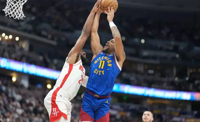 Houston Rockets guard Josh Okogie, left, blocks a shot by Denver Nuggets guard Bruce Brown in the first half of an NBA basketball game, Wednesday, March 11, 2026, in Denver. (AP Photo/David Zalubowski)