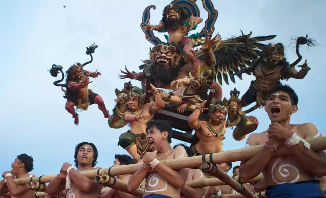 Participants carry giant effigies called "ogoh-ogoh" representing evil spirits that need to be cleansed during a parade on the evening of "Nyepi" or the Day of Silence that marks Balinese Hindu's New Year in Denpasar, Bali, Indonesia, Wednesday, March 18, 2026. (AP Photo/Firdia Lisnawati)