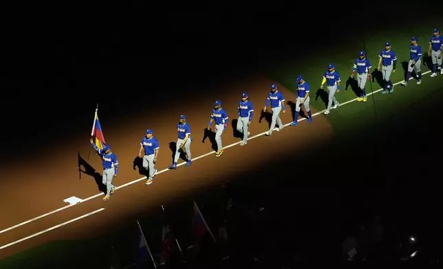 Venezuela enters the field at the start of the championship game of the World Baseball Classic against the United States, Tuesday, March 17, 2026, in Miami. (AP Photo/Lynne Sladky)