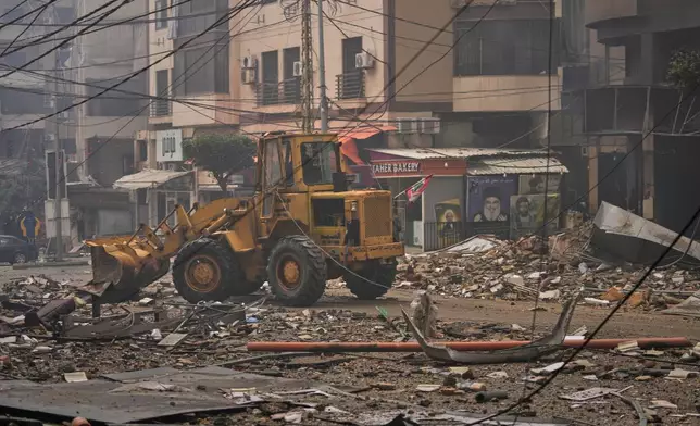 A bulldozer clears debris from the rubble of buildings destroyed in an Israeli airstrike in Dahiyeh, Beirut's southern suburbs, Lebanon, Sunday, March 15, 2026. (AP Photo/Hassan Ammar)