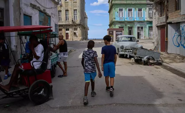 People walk outside during a blackout in Havana, Cuba, Monday, March 16, 2026. (AP Photo/Ramon Espinosa)