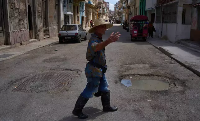 A man walks outside during a blackout in Havana, Cuba, Monday, March 16, 2026. (AP Photo/Ramon Espinosa)