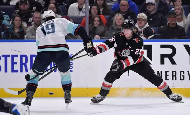 Buffalo Sabres defenseman Rasmus Dahlin, right, defends against Seattle Kraken left wing Jared McCann, left, during the first period of an NHL hockey game Saturday, March 28, 2026, in Buffalo, N.Y. (AP Photo/Adrian Kraus)