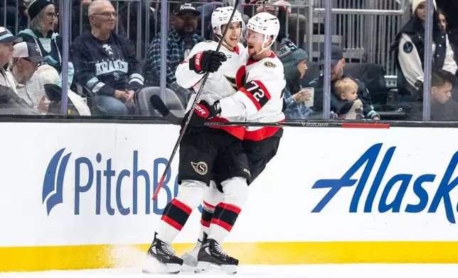 Ottawa Senators forward Dylan Cozens, left, and defenseman Thomas Chabot celebrate a goal during the first period of an NHL hockey game against the Seattle Kraken Saturday, March 7, 2026, in Seattle. (AP Photo/Stephen Brashear)