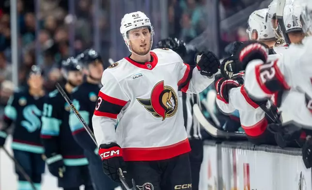 Ottawa Senators defenseman Tyler Kleven celebrates with teammates on the bench after a goal during the first period of an NHL hockey game against the Seattle Kraken, Saturday, March 7, 2026, in Seattle. (AP Photo/Stephen Brashear)