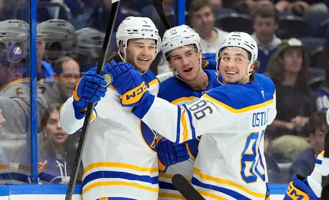 Buffalo Sabres center Josh Norris (9) celebrates his goal against the Tampa Bay Lightning with right wing Josh Doan, and center Noah Ostlund (86) during the first period of an NHL hockey game Saturday, Feb. 28, 2026, in Tampa, Fla. (AP Photo/Chris O'Meara)