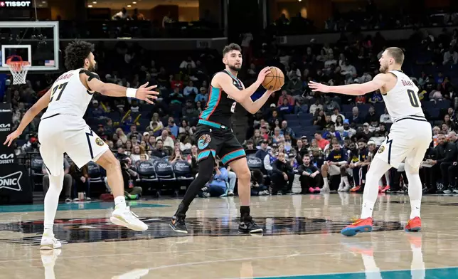 Memphis Grizzlies guard Ty Jerome (2) handles the ball between Denver Nuggets guards Jamal Murray (27) and Christian Braun (0) in the second half of an NBA basketball game Wednesday, March 18, 2026, in Memphis, Tenn. (AP Photo/Brandon Dill)