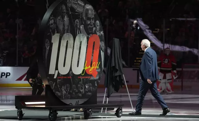 Anaheim Ducks head coach Joel Quenneville walks onto the ice to be honored for his 1,000th career coaching victory before an NHL hockey game against the Calgary Flames Sunday, March 1, 2026, in Anaheim, Calif. (AP Photo/Gregory Bull)