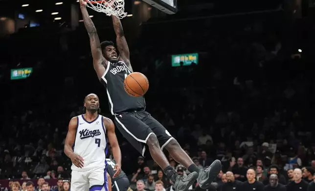 Brooklyn Nets' Drake Powell (4) dunks the ball in front of Sacramento Kings' Precious Achiuwa (9) during the second half of an NBA basketball game Sunday, March 29, 2026, in New York. (AP Photo/Frank Franklin II)