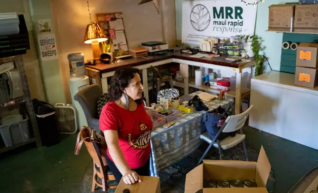 Nicole Huguenin, executive director of Maui Rapid Response, a nonprofit supporting Maui fire survivors with cash assistance, organizes canned food at the organization's warehouse in Kahului, Hawaii, Wednesday, March 4, 2026. (AP Photo/Mengshin Lin)