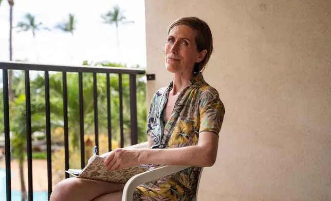 Mari Younger poses for a portrait on the balcony of her converted hotel room where she lives after being displaced by the Maui fires two years prior, in Kihei, Hawaii, Wednesday, March 4, 2026. (AP Photo/Mengshin Lin)