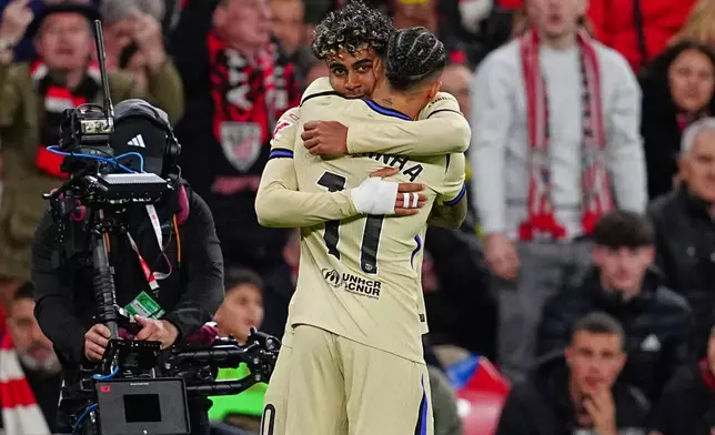 Barcelona's Lamine Yamal, back, is congratulated after scoring his side's opening goal during the Spanish La Liga soccer match between Athletic Bilbao and Barcelona in Bilbao, Spain, Saturday, March 7, 2026. (AP Photo/Miguel Oses)