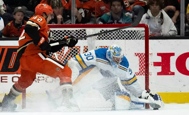 St. Louis Blues goaltender Joel Hofer, right, freezes the puck in front of Anaheim Ducks center Tim Washe during the second period of an NHL hockey game, Sunday, March 8, 2026, in Anaheim, Calif. (AP Photo/Kyusung Gong)