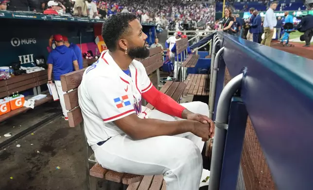 Dominican Republic third baseman Junior Caminero sits in the dugout at the end of a World Baseball Classic semifinal game against the United States, Sunday, March 15, 2026, in Miami. (AP Photo/Lynne Sladky)