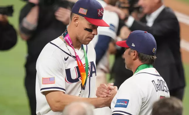 United States right fielder Aaron Judge shakes hands with manager Mark DeRosa after receiving their silver medals following the championship game of the World Baseball Classic against Venezuela, Tuesday, March 17, 2026, in Miami. (AP Photo/Lynne Sladky)