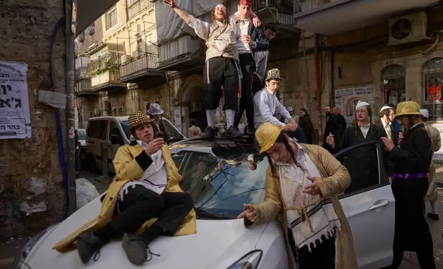 Ultra-Orthodox Jewish men celebrate the festival of Purim in Jerusalem, amid the war with Iran Wednesday, March 4, 2026. (AP Photo/Ohad Zwigenberg)