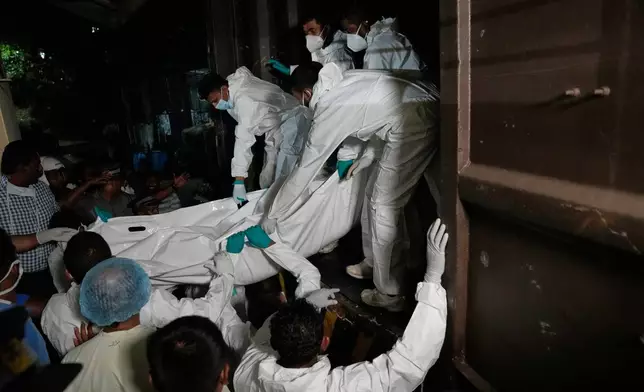 Healthcare workers unload the bodies of Iranian sailors from a vehicle who died when their IRIS Dena warship sank outside Sri Lanka's territorial waters, in Galle, Sri Lanka, Wednesday, March 4, 2026. (AP Photo/Eranga Jayawardena)