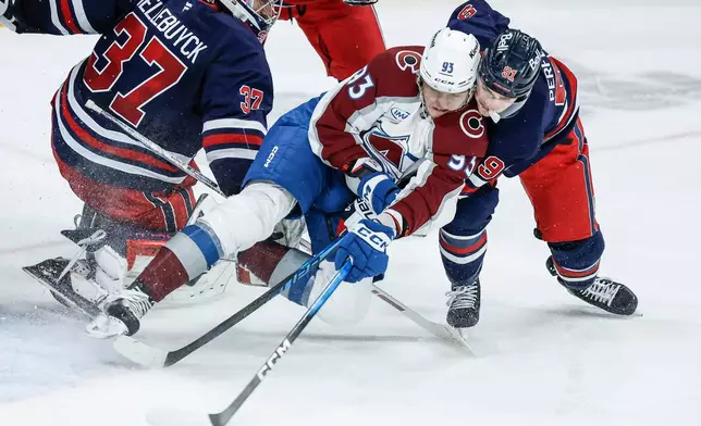 Winnipeg Jets' Cole Perfetti (91) vies for the puck with Colorado Avalanche's Zakhar Bardakov (93) during second period of an NHL game in Winnipeg, Manitoba, Saturday, March 14, 2026. (John Woods/The Canadian Press via AP)