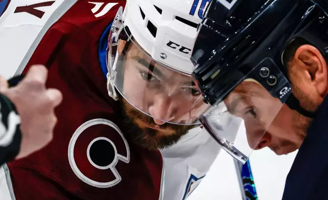 Winnipeg Jets' Jonathan Toews (19) and Colorado Avalanche's Nicolas Roy (10) face-off during the first period of an NHL game in Winnipeg, Manitoba, Saturday, March 14, 2026. (John Woods/The Canadian Press via AP)