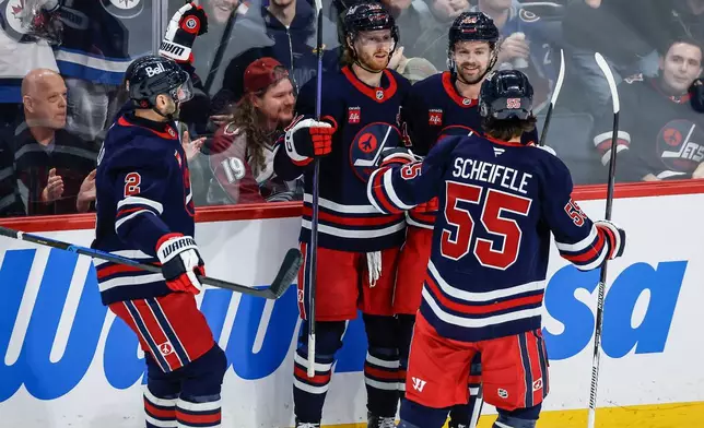 Winnipeg Jets players celebrate Kyle Connor's (81) goal against the Colorado Avalanche during the second period of an NHL game in Winnipeg, Saturday, March 14, 2026. (John Woods/The Canadian Press via AP)