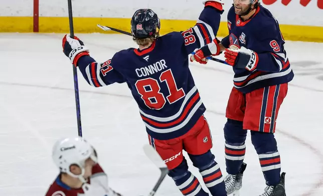 Winnipeg Jets' Alex Iafallo (9) and Kyle Connor (81) celebrate Iafallo's goal against the Colorado Avalanche during second period of an NHL game in Winnipeg, Manitoba, Saturday, March 14, 2026. (John Woods/The Canadian Press via AP)