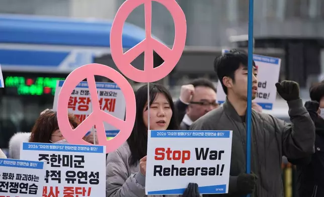 Protesters hold signs to oppose the joint military exercise between the U.S. and South Korea, near the U.S. Embassy in Seoul, South Korea, Monday, March 9, 2026. (AP Photo/Lee Jin-man)