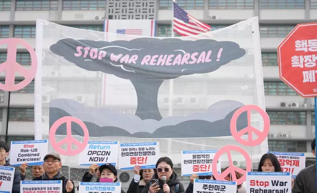 Protesters hold signs to oppose the joint military exercise between the U.S. and South Korea, near the U.S. Embassy in Seoul, South Korea, Monday, March 9, 2026. (AP Photo/Lee Jin-man)