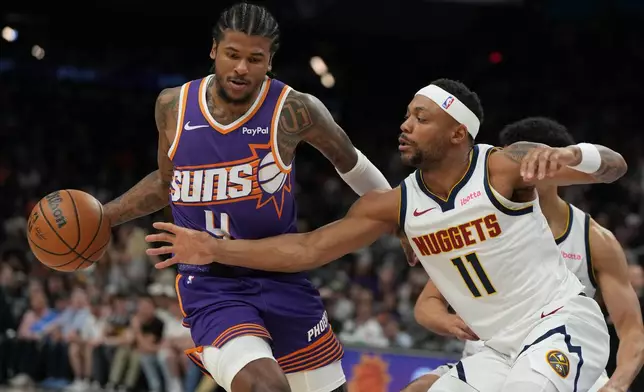 Phoenix Suns guard Jalen Green (4) shields the ball from Denver Nuggets guard/forward Bruce Brown during the first half of an NBA basketball game, Tuesday, March 24, 2026, in Phoenix. (AP Photo/Rick Scuteri)