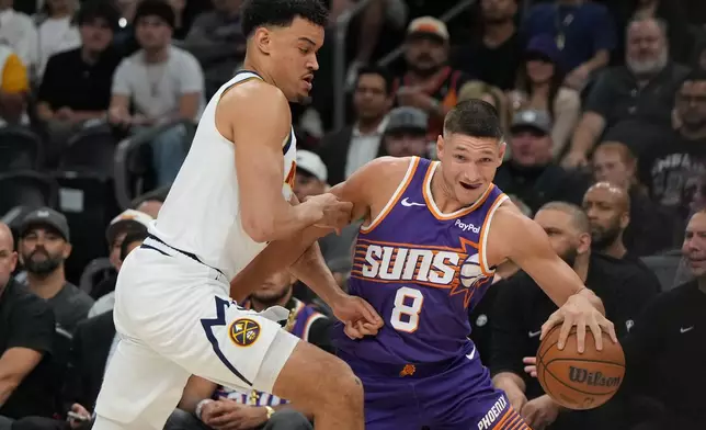 Phoenix Suns guard Grayson Allen (8) drives on Denver Nuggets forward Spencer Jones during the first half of an NBA basketball game, Tuesday, March 24, 2026, in Phoenix. (AP Photo/Rick Scuteri)
