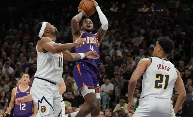 Phoenix Suns guard Jalen Green (4) shoots over Denver Nuggets guard Bruce Brown and forward Spencer Jones (21) during the first half of an NBA basketball game, Tuesday, March 24, 2026, in Phoenix. (AP Photo/Rick Scuteri)