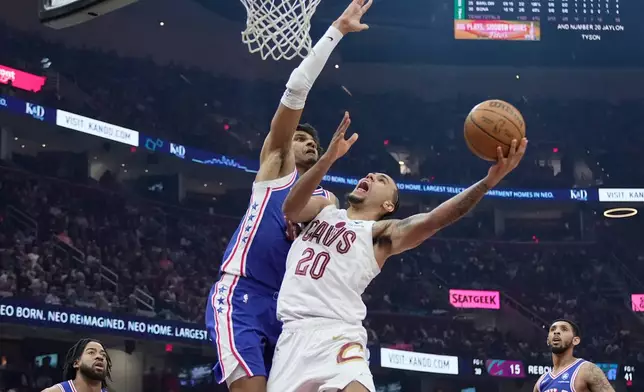 Cleveland Cavaliers guard Jaylon Tyson (20) shoots as Philadelphia 76ers forward Dominick Barlow, left, defends in the first half of an NBA basketball game in Cleveland, Monday, March 9, 2026. (AP Photo/Sue Ogrocki)