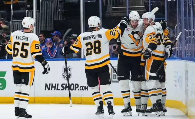 Pittsburgh Penguins' Anthony Mantha (39) celebrates with teammates after scoring a goal during the second period of an NHL hockey game against the New York IslandersMonday, March 30, 2026, in Elmont, N.Y. (AP Photo/Frank Franklin II)