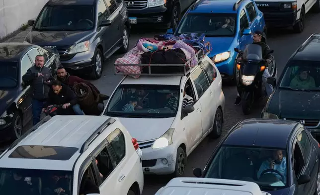 Displaced people fleeing Israeli airstrikes in Dahiyeh, Beirut's southern suburbs, sit in traffic on a highway in Beirut, Lebanon, Thursday, March 5, 2026. (AP Photo/Bilal Hussein)