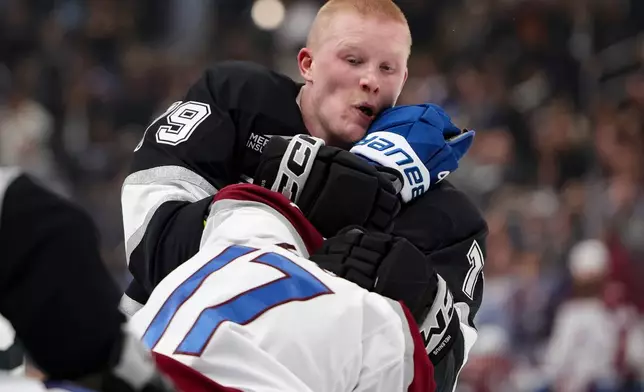 Los Angeles Kings center Samuel Helenius, top, and Colorado Avalanche center Parker Kelly fight during the second period of an NHL hockey game Monday, March 2, 2026 in Los Angeles. (AP Photo/Ryan Sun)