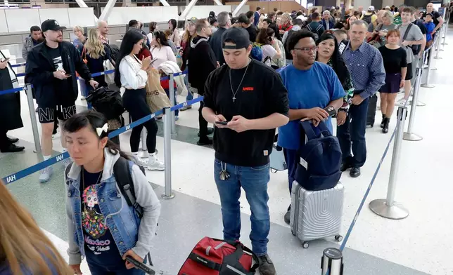 Air travelers endure long lines and two-hour wait times at the TSA security check point at Terminal E at the George Bush Intercontinental Airport Friday, March 20, 2026, in Houston. (AP Photo/Michael Wyke)