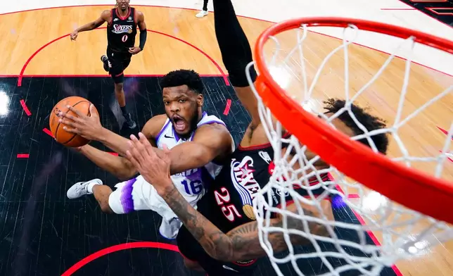 Utah Jazz's EJ Harkless, left, goes up for a shot against Philadelphia 76ers' Dom Barlow, right, during the first half of an NBA basketball game, Wednesday, March 4, 2026, in Philadelphia. (AP Photo/Chris Szagola)