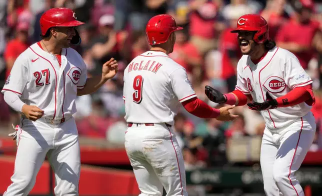 Cincinnati Reds' Eugenio Suárez (28), celebrates with Matt McLain (9) and Sal Stewart (27) after hitting a three-run homer during the sixth inning of a baseball game against the Boston Red Sox in Cincinnati, Sunday, March 29, 2026. (AP Photo/Carolyn Kaster)