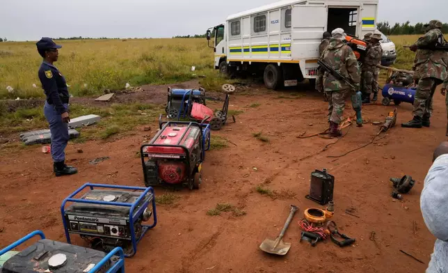 South African National Defense Force soldiers and police officers load recovered generators and machinery left behind by illegal miners, during a patrol in Randfontein, west of Johannesburg, South Africa, Thursday, March 12, 2026. (AP Photo/Themba Hadebe)