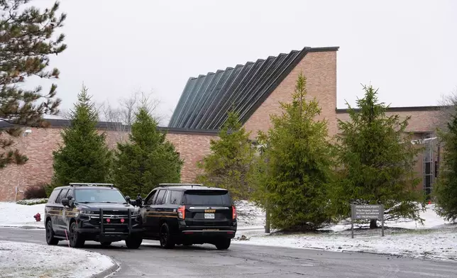 Police vehicles sit outside the Temple Israel synagogue Friday, March 13, 2026, in West Bloomfield Township, Mich. (AP Photo/Paul Sancya)