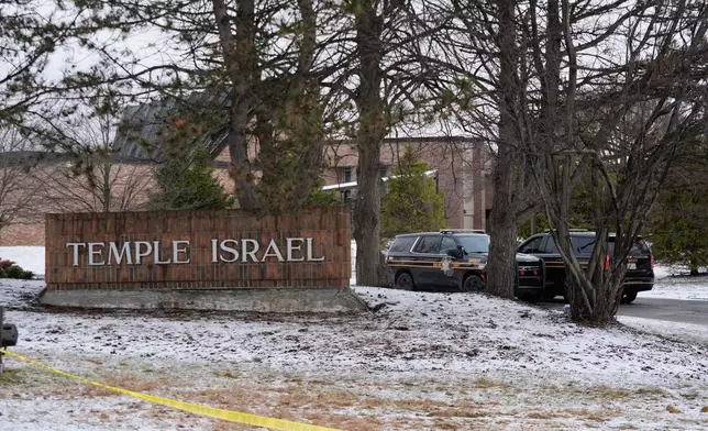 Police vehicles sit outside the Temple Israel synagogue Friday, March 13, 2026, in West Bloomfield Township, Mich. (AP Photo/Paul Sancya)