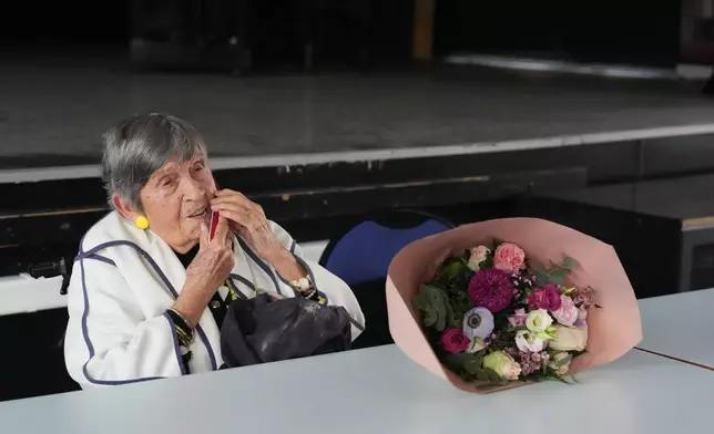 Ginette Kolinka, a 101-year-old survivor of Auschwitz, makes a phone call after she met some pupils in a Paris-region high school in Saint-Maur-des-Fosses, outside Paris, France, March 21, 2026. (AP Photo/Thibault Camus)