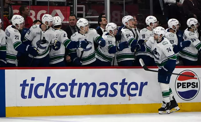 Vancouver Canucks' Jake DeBrusk (74) celebrates with teammates at the bench after scoring during the first period of an NHL hockey game against the Chicago Blackhawks in Chicago, Friday, March 6, 2026. (AP Photo/Paul Beaty)