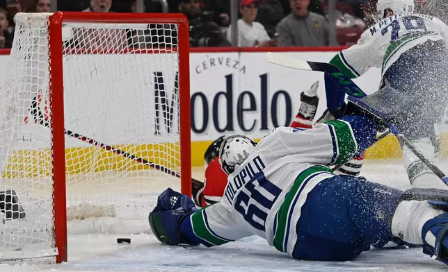 Vancouver Canucks goalie Nikita Tolopilo (60) misses a goal by Chicago Blackhawks' Ryan Donato during the first period of an NHL hockey game in Chicago, Friday, March 6, 2026. (AP Photo/Paul Beaty)