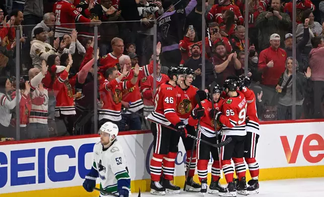 Chicago Blackhawks' Frank Nazar (91) celebrates with teammates after scoring a goal during the second period of an NHL hockey game against the Vancouver Canucks in Chicago, Friday, March 6, 2026. (AP Photo/Paul Beaty)