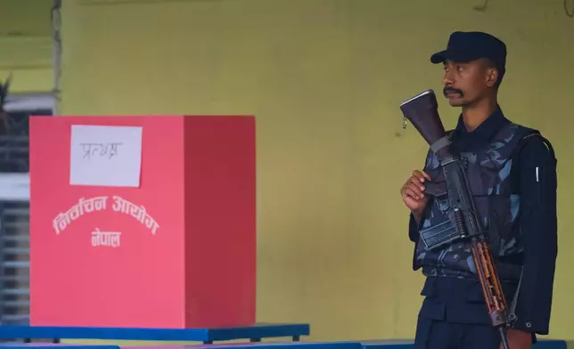 A Nepalese police officer stands guard near a ballot box as the voting commences for the parliamentary election in Kathmandu, Nepal, Thursday, March 5, 2026. (AP Photo/Niranjan Shrestha)