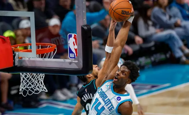 Charlotte Hornets forward Moussa Diabate (14) drives for a dunk past Portland Trail Blazers forward Toumani Camara during the second half of an NBA basketball game in Charlotte, N.C., Saturday, Feb. 28, 2026. (AP Photo/Nell Redmond)