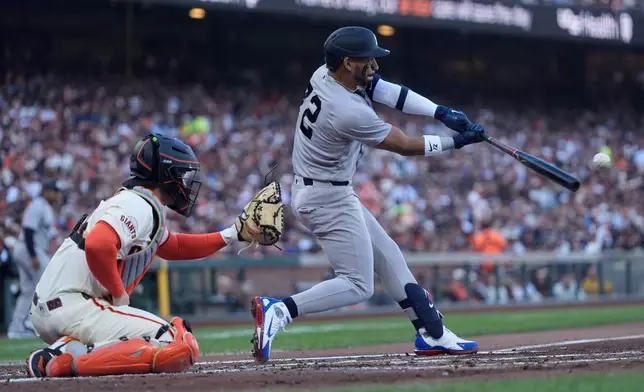 New York Yankees' José Caballero, right, hits an RBI double in front of San Francisco Giants catcher Patrick Bailey, left, during the second inning of a baseball game in San Francisco, Wednesday, March 25, 2026. (AP Photo/Jeff Chiu)