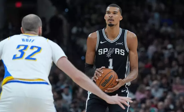 San Antonio Spurs forward Victor Wembanyama (1) looks to shoot against Indiana Pacers center Jay Huff (32) as he watches his shot during the first half of an NBA basketball game in San Antonio, Saturday, March 21,2026. (AP Photo/Eric Gay)